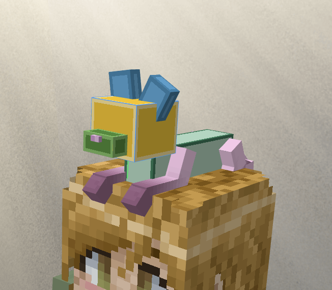A work-in-progress screenshot of a blocky creature sat atop a minecraft player's head.